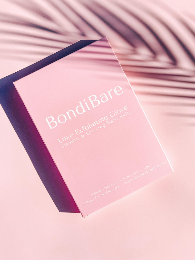 Luxury exfoliating glove with a palm tree shadow and pink packaging